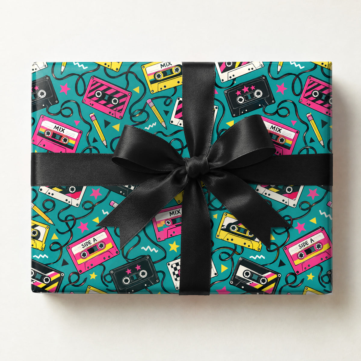 Mixtape Cassette Wrapping Paper, a gift box wrapped in it and tied with a satin ribbon