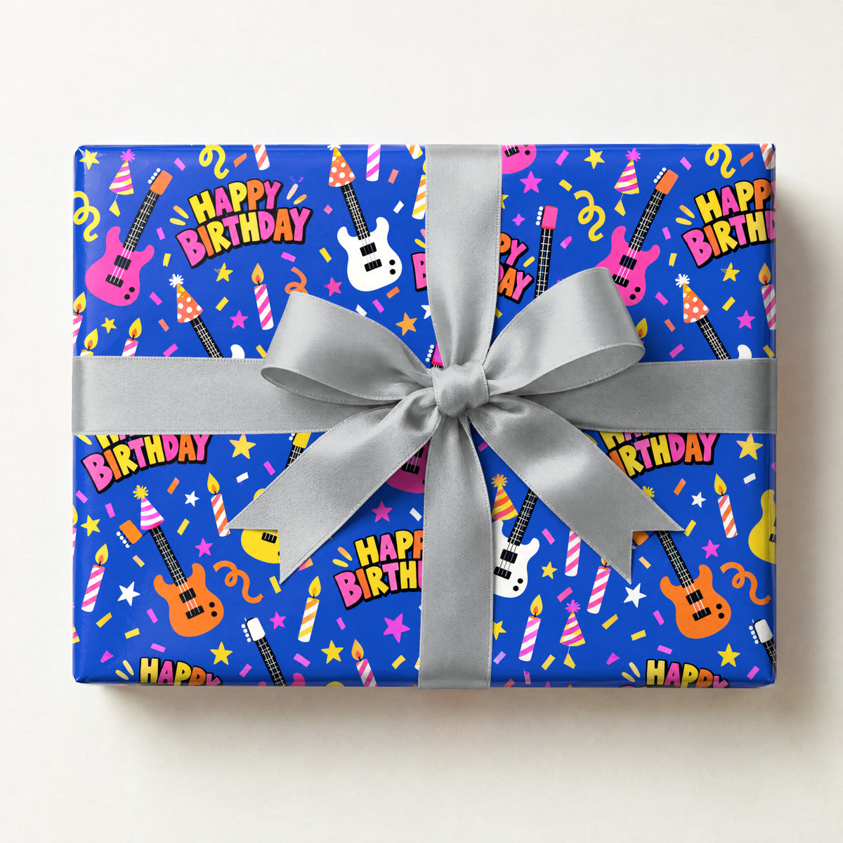 Happy Birthday Rock Star Wrapping Paper, a gift box wrapped in it and tied with a satin ribbon