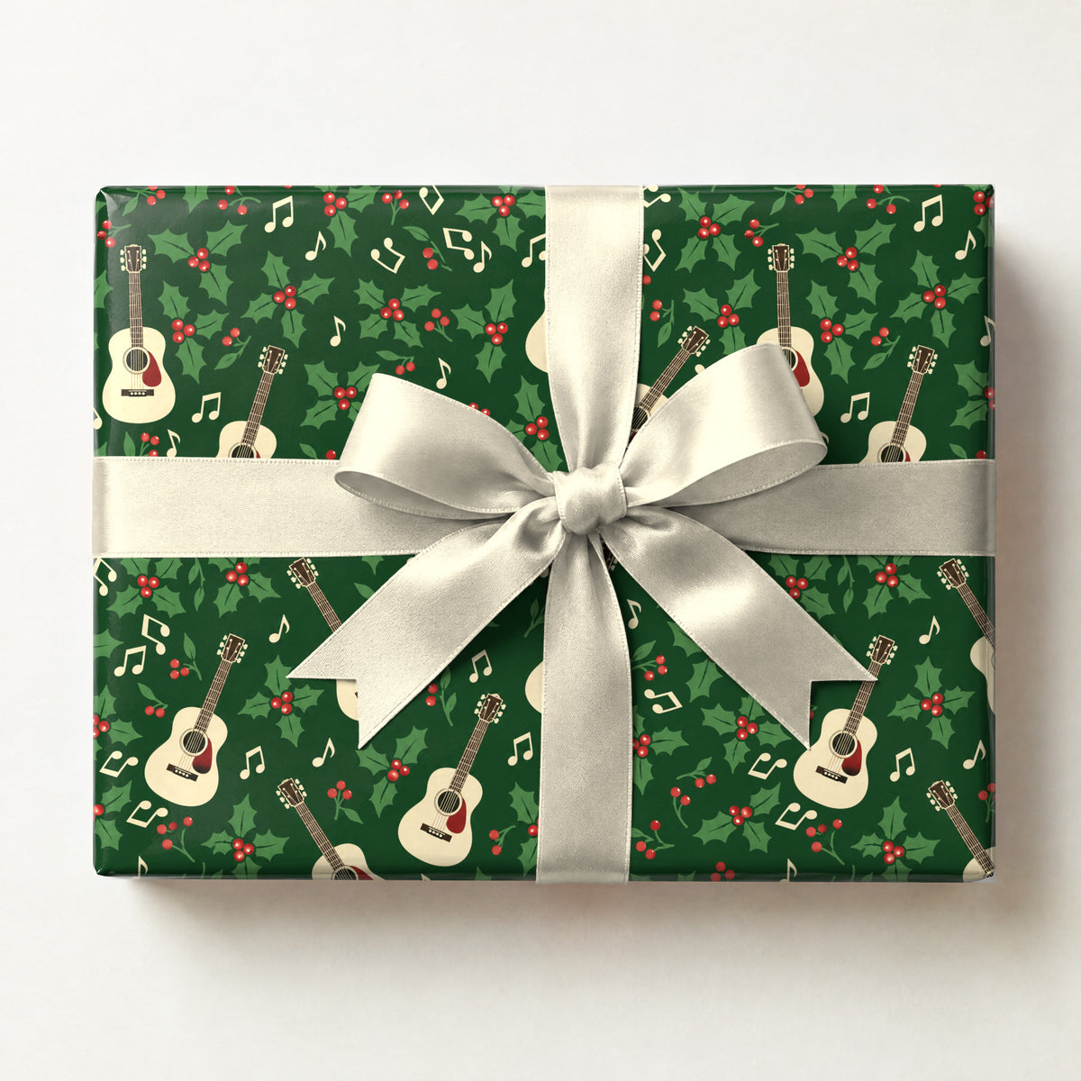 Holly Jolly Acoustic Guitar Wrapping Paper, a gift box wrapped in it and tied with a satin ribbon