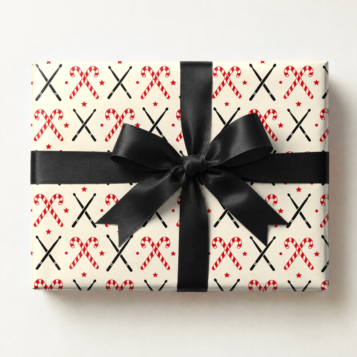 Drumstick Candy Cane Cross Wrapping Paper, a gift box wrapped in it and tied with a satin ribbon