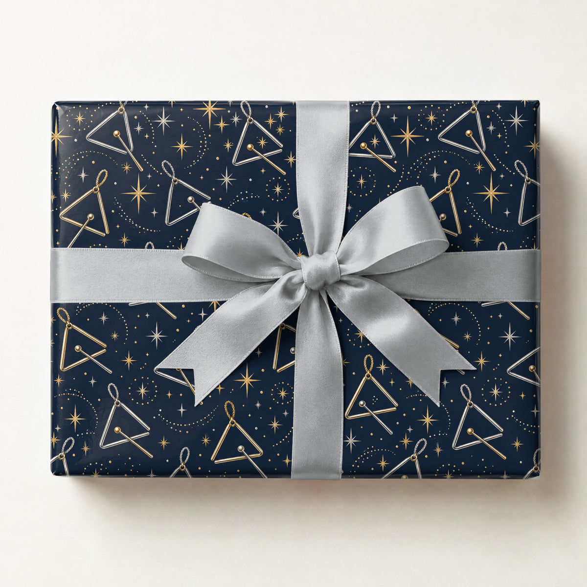 Twinkling Triangle Stars Wrapping Paper, a gift box wrapped in it and tied with a satin ribbon