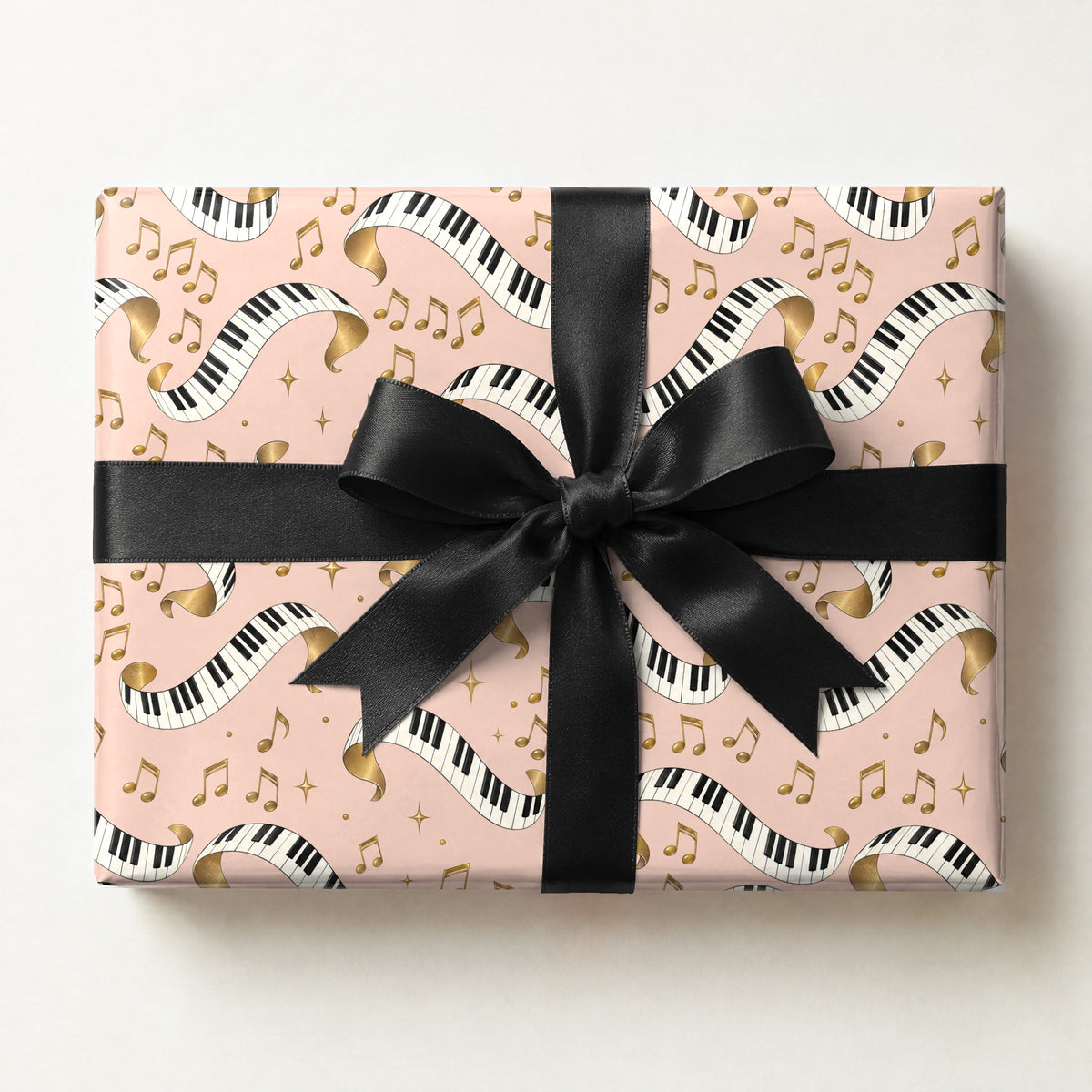 Piano Keys Wrapping Paper, a gift box wrapped in it and tied with a satin ribbon