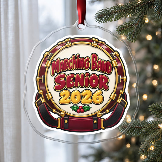 Marching Band Senior 2026 clear acrylic Christmas ornament hanging on a Christmas tree by a window in soft daylight