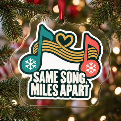 Same Song, Miles Apart Long Distance clear acrylic Christmas ornament hanging on a Christmas tree with red and white baubles