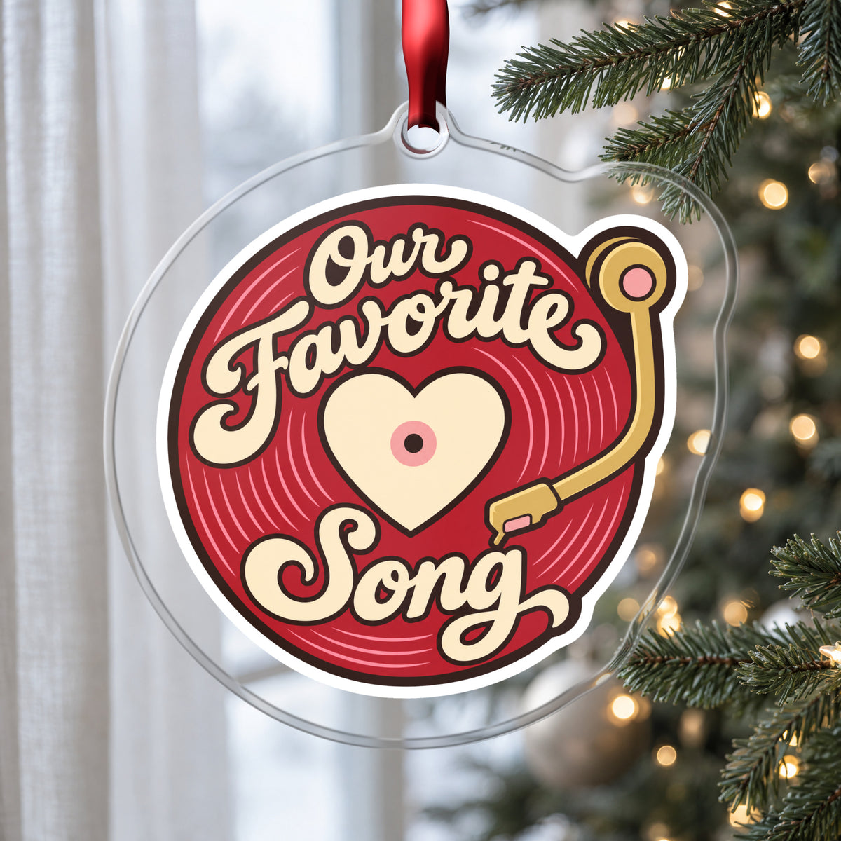 Our Favorite Song Vinyl Record clear acrylic Christmas ornament hanging on a Christmas tree by a window in soft daylight