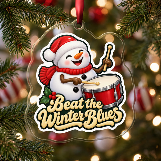 Beat the Winter Blues Snowman Drummer clear acrylic Christmas ornament hanging on a Christmas tree with red and white baubles