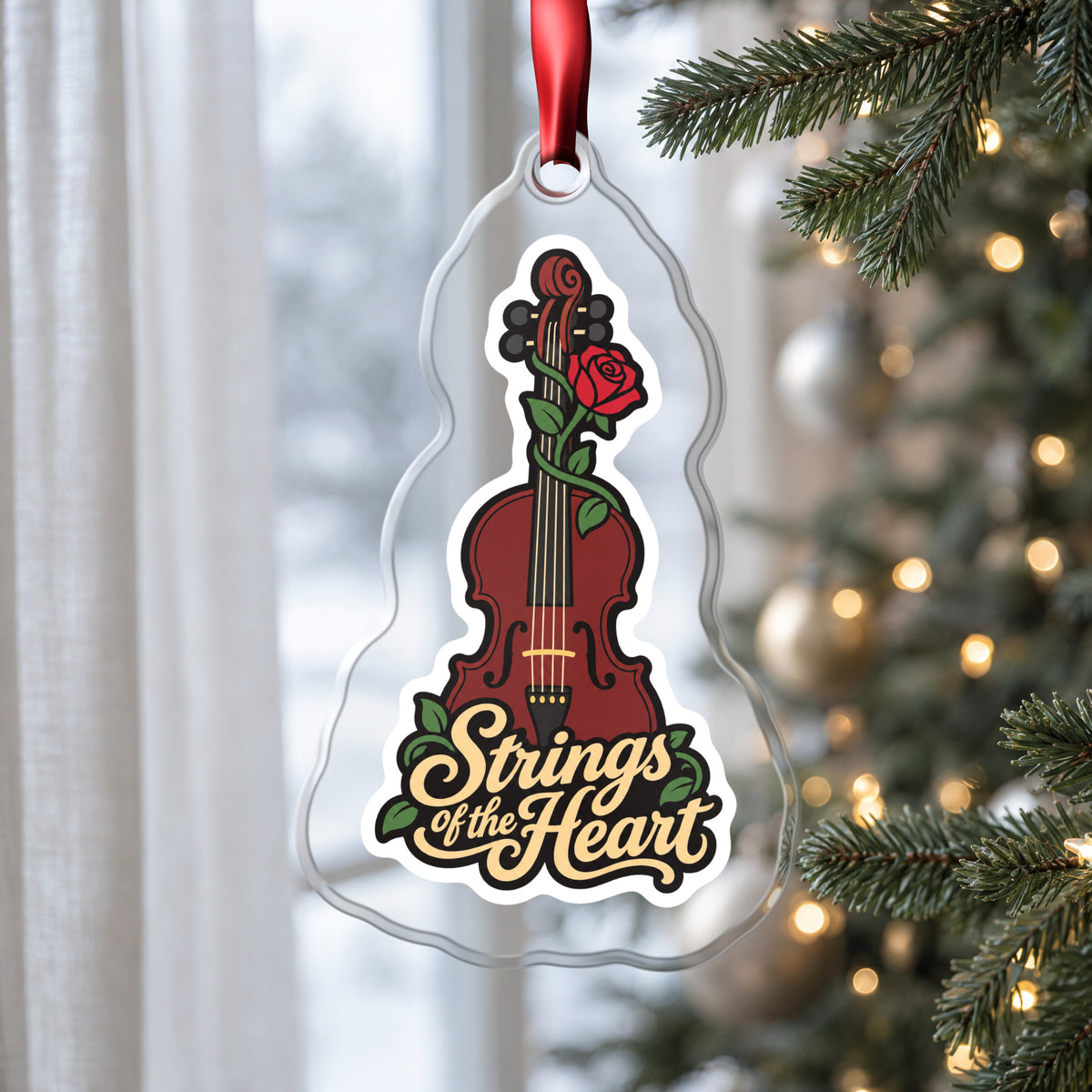 Strings of the Heart Violin clear acrylic Christmas ornament hanging on a Christmas tree by a window in soft daylight
