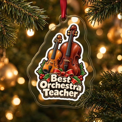 Best Orchestra Teacher clear acrylic Christmas ornament hanging on a lit Christmas tree with warm gold lights