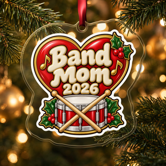 Band Mom 2026 clear acrylic Christmas ornament hanging on a lit Christmas tree with warm gold lights
