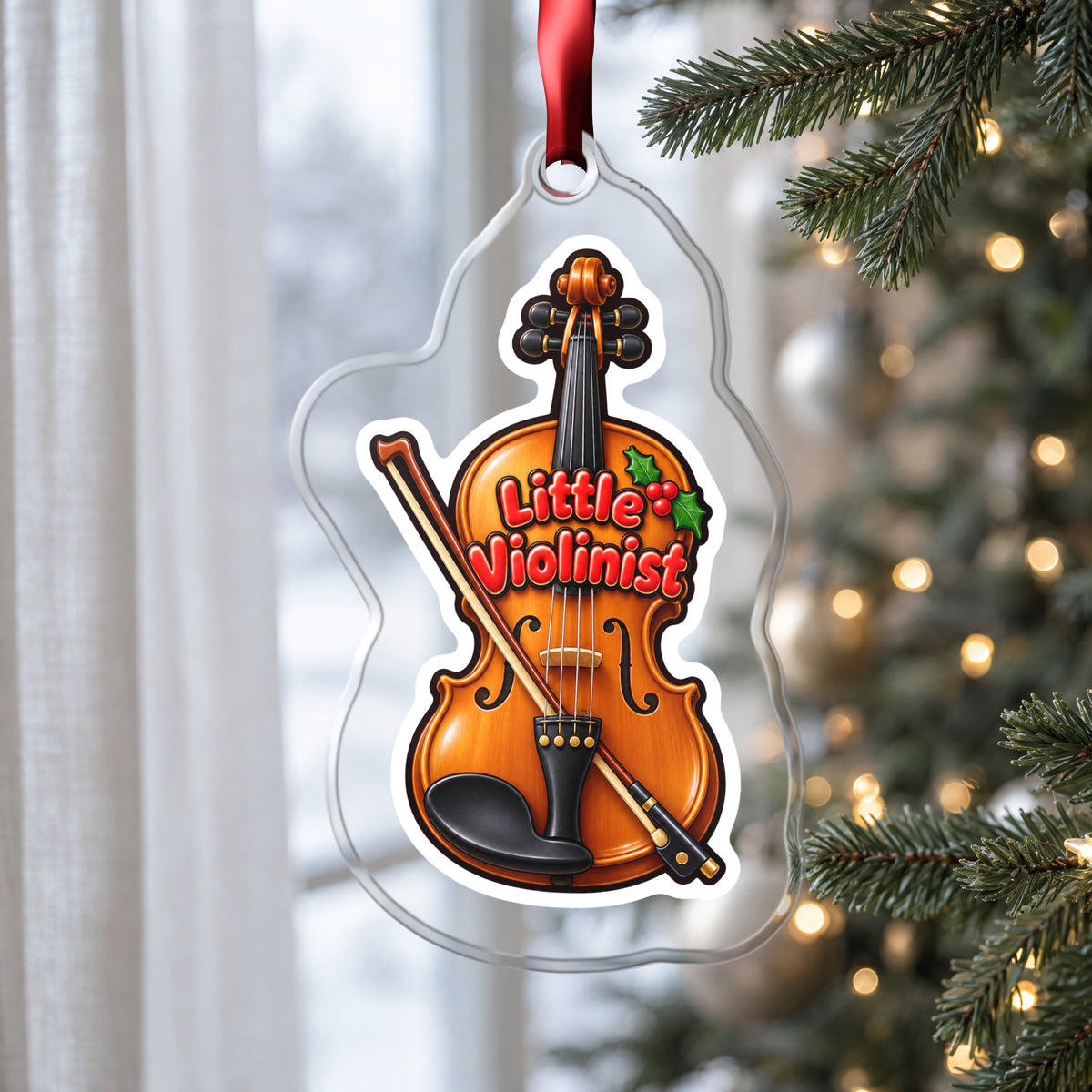 Little Violinist clear acrylic Christmas ornament hanging on a Christmas tree by a window in soft daylight