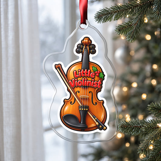 Little Violinist clear acrylic Christmas ornament hanging on a Christmas tree by a window in soft daylight