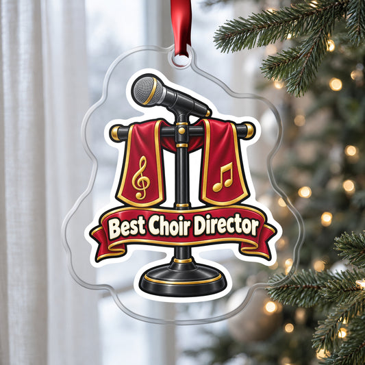 Best Choir Director clear acrylic Christmas ornament hanging on a Christmas tree by a window in soft daylight