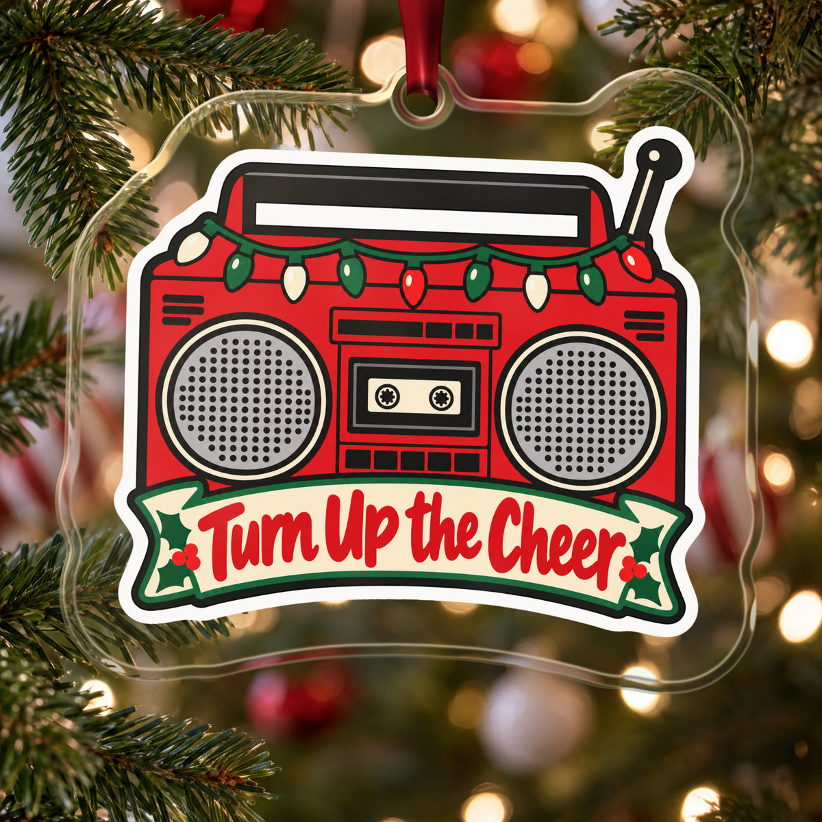 Turn Up the Cheer Boombox clear acrylic Christmas ornament hanging on a Christmas tree with red and white baubles
