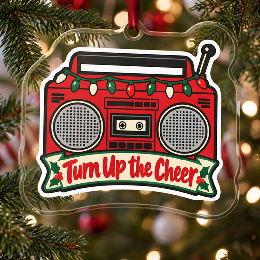 Turn Up the Cheer Boombox clear acrylic Christmas ornament hanging on a Christmas tree with red and white baubles