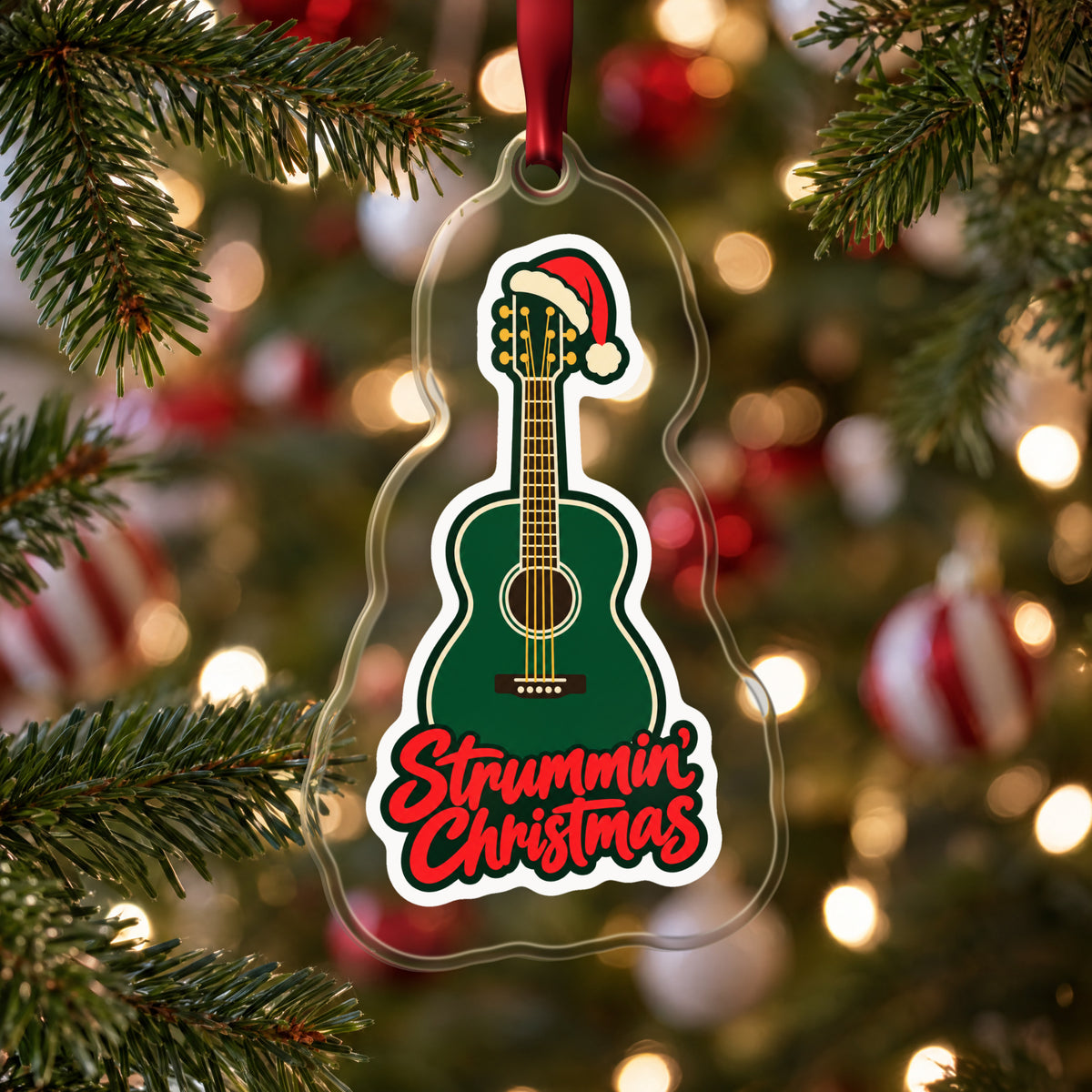 Strummin' Christmas Acoustic Guitar clear acrylic Christmas ornament hanging on a Christmas tree with red and white baubles
