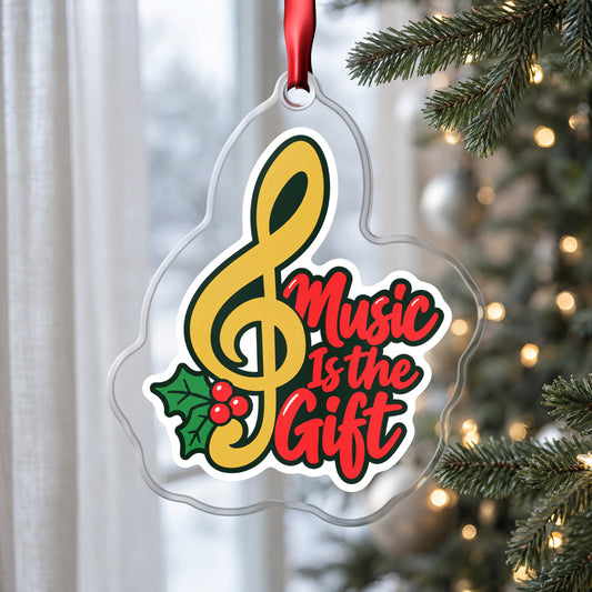 Music Is the Gift Treble Clef clear acrylic Christmas ornament hanging on a Christmas tree by a window in soft daylight