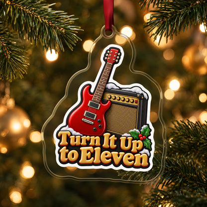 Turn It Up to Eleven Guitar and Amp clear acrylic Christmas ornament hanging on a lit Christmas tree with warm gold lights
