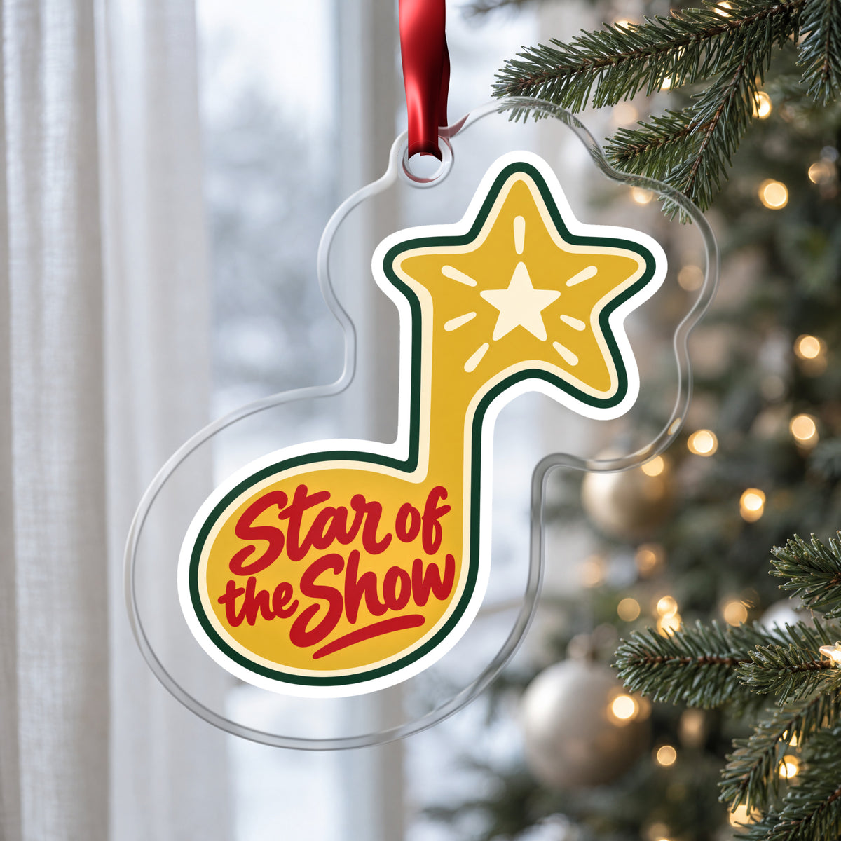 Star of the Show Music Note clear acrylic Christmas ornament hanging on a Christmas tree by a window in soft daylight