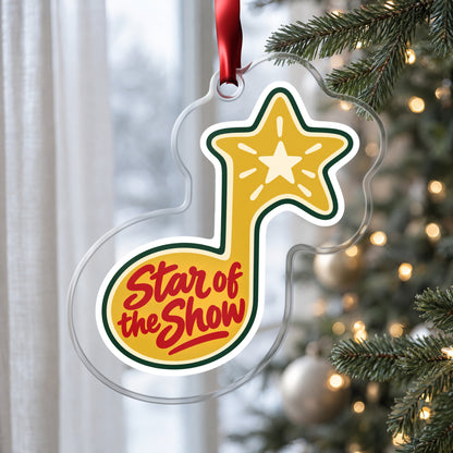 Star of the Show Music Note clear acrylic Christmas ornament hanging on a Christmas tree by a window in soft daylight