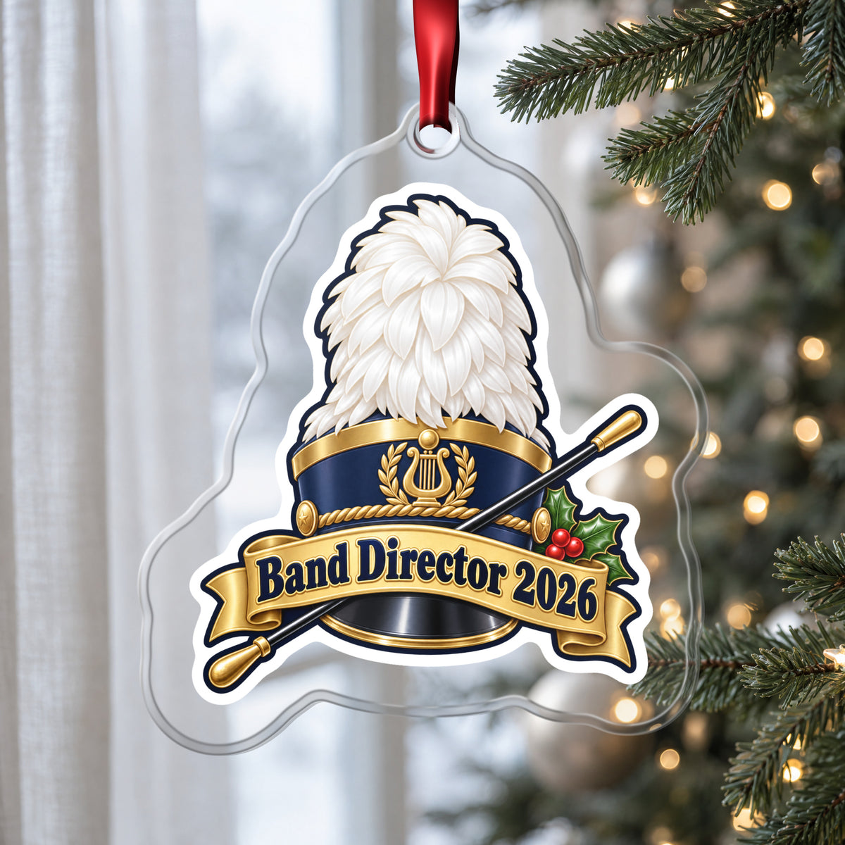 Band Director 2026 clear acrylic Christmas ornament hanging on a Christmas tree by a window in soft daylight