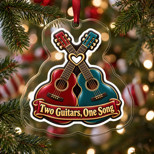 Two Guitars, One Song Couples clear acrylic Christmas ornament hanging on a Christmas tree with red and white baubles