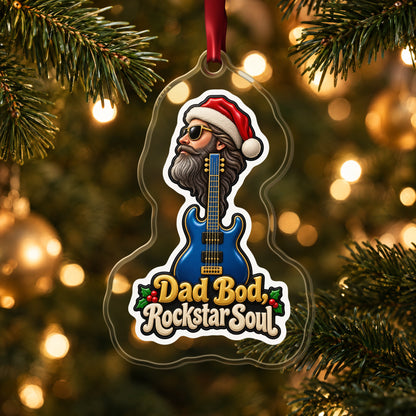 Dad Bod, Rockstar Soul Guitar clear acrylic Christmas ornament hanging on a lit Christmas tree with warm gold lights
