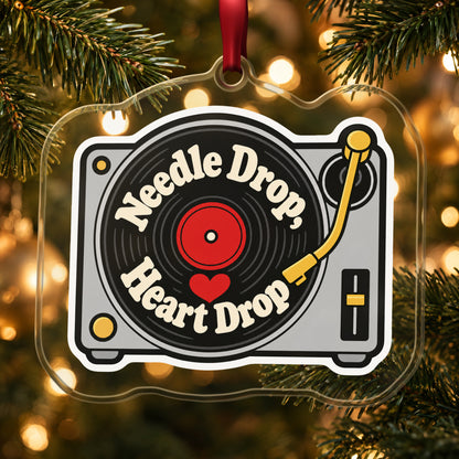 Needle Drop, Heart Drop Turntable clear acrylic Christmas ornament hanging on a lit Christmas tree with warm gold lights