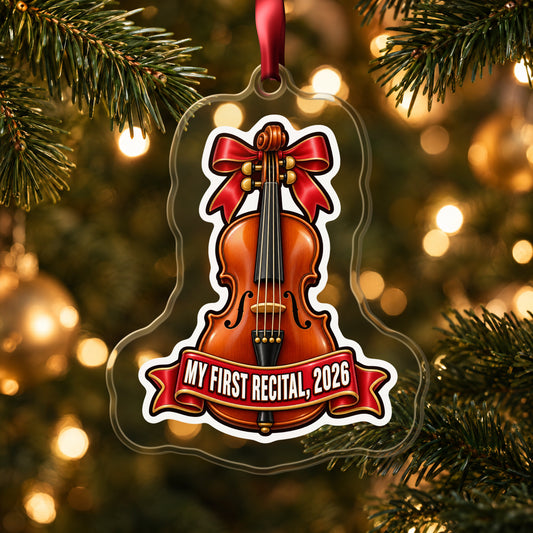 My First Violin Recital 2026 clear acrylic Christmas ornament hanging on a lit Christmas tree with warm gold lights