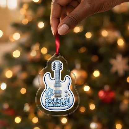 Rocking All Season Electric Guitar clear acrylic Christmas ornament held by its red ribbon in a hand, shown at its real size