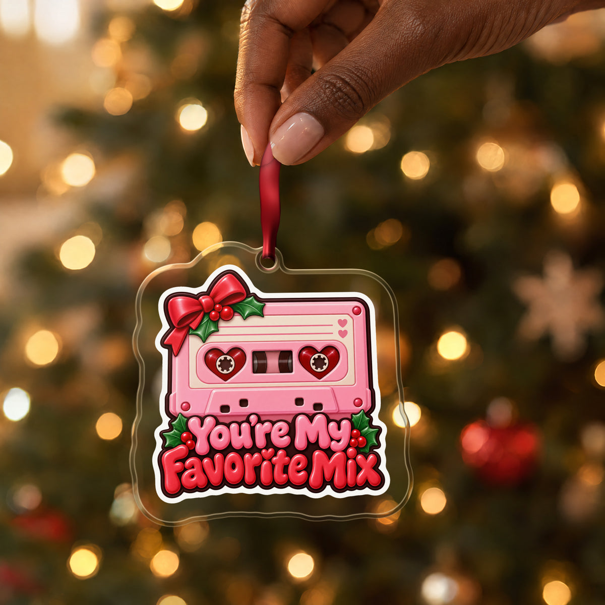 You're My Favorite Mix Cassette clear acrylic Christmas ornament held by its red ribbon in a hand, shown at its real size