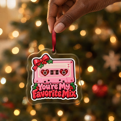 You're My Favorite Mix Cassette clear acrylic Christmas ornament held by its red ribbon in a hand, shown at its real size