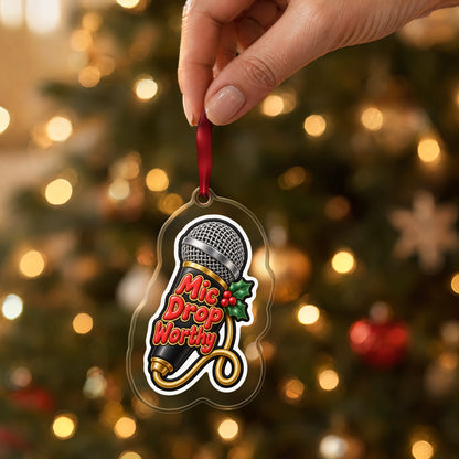 Mic Drop Worthy Microphone clear acrylic Christmas ornament held by its red ribbon in a hand, shown at its real size