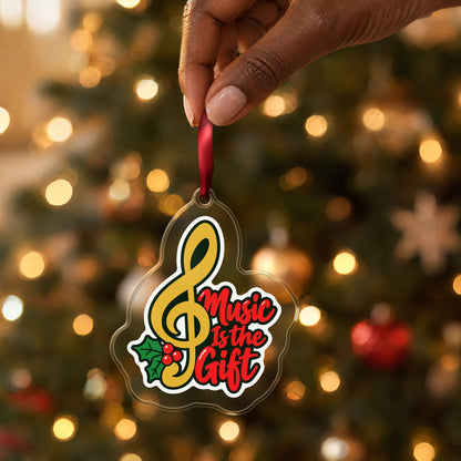 Music Is the Gift Treble Clef clear acrylic Christmas ornament held by its red ribbon in a hand, shown at its real size