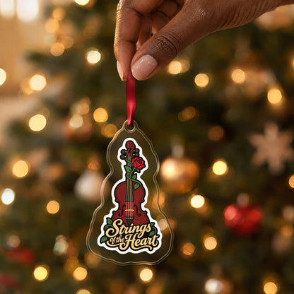 Strings of the Heart Violin clear acrylic Christmas ornament held by its red ribbon in a hand, shown at its real size