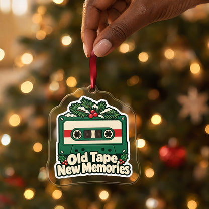 Old Tape, New Memories Cassette clear acrylic Christmas ornament held by its red ribbon in a hand, shown at its real size