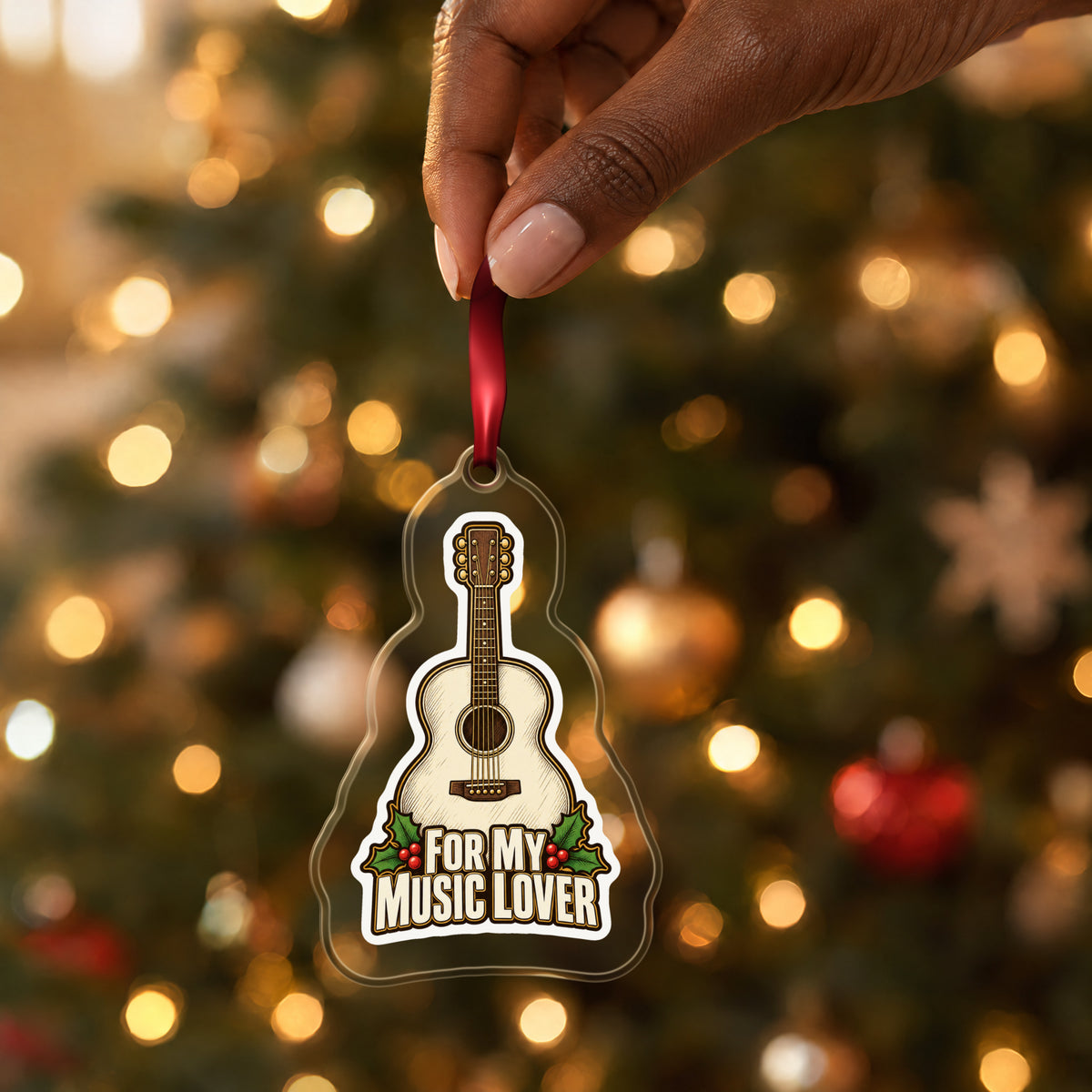 For My Music Lover Acoustic Guitar clear acrylic Christmas ornament held by its red ribbon in a hand, shown at its real size