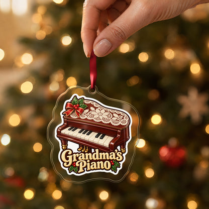 Grandma's Piano clear acrylic Christmas ornament held by its red ribbon in a hand, shown at its real size
