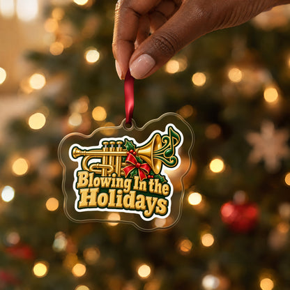 Blowing In the Holidays Trumpet clear acrylic Christmas ornament held by its red ribbon in a hand, shown at its real size