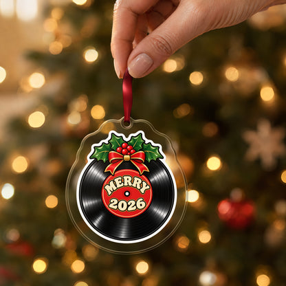 Merry 2026 Vinyl Record clear acrylic Christmas ornament held by its red ribbon in a hand, shown at its real size