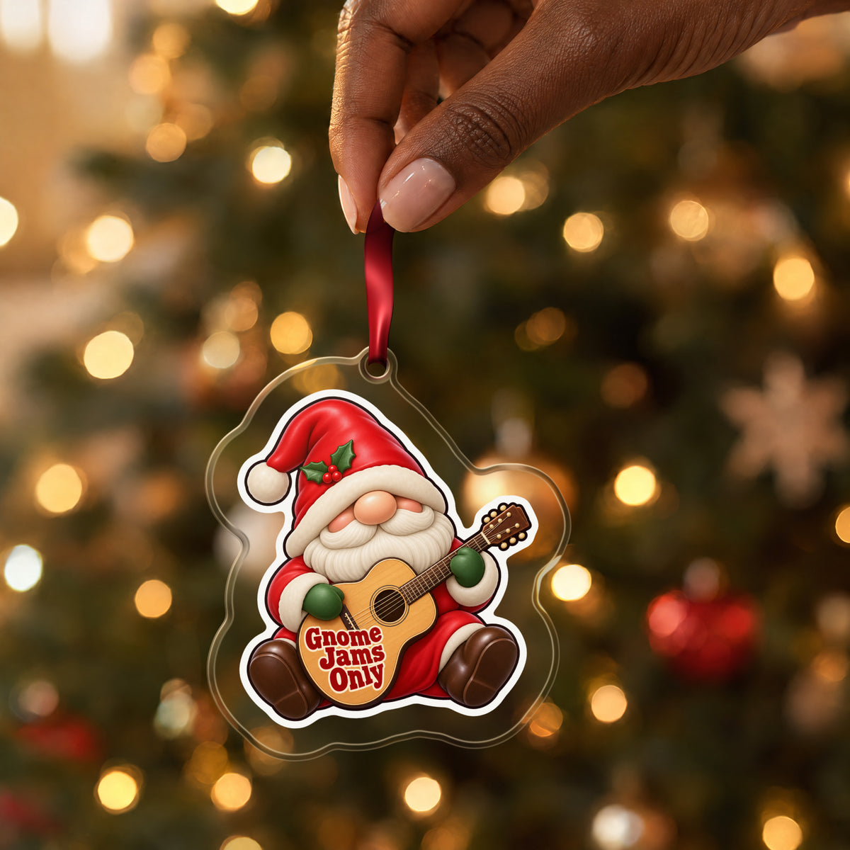 Gnome Jams Only Guitar Gnome clear acrylic Christmas ornament held by its red ribbon in a hand, shown at its real size
