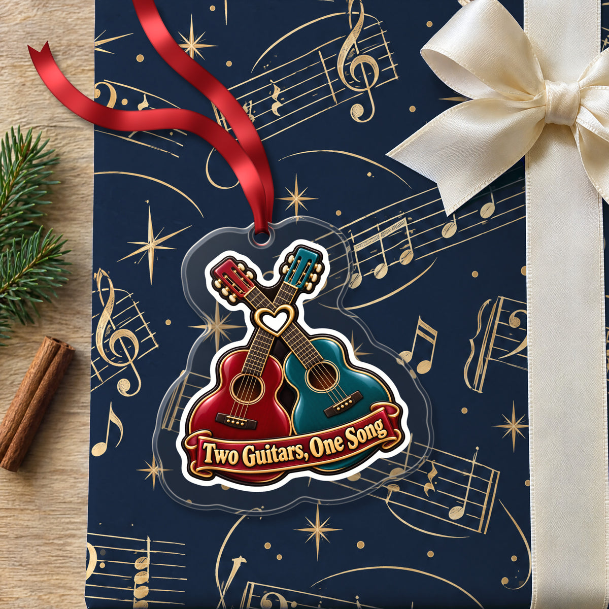 Two Guitars, One Song Couples clear acrylic Christmas ornament lying on a gift wrapped in Rhythm and Beat music wrapping paper