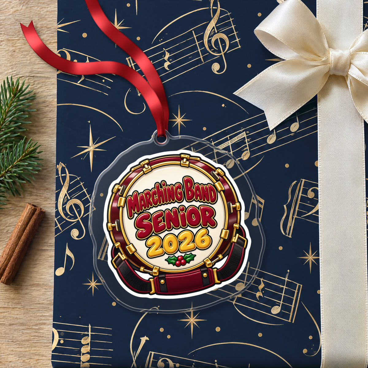 Marching Band Senior 2026 clear acrylic Christmas ornament lying on a gift wrapped in Rhythm and Beat music wrapping paper