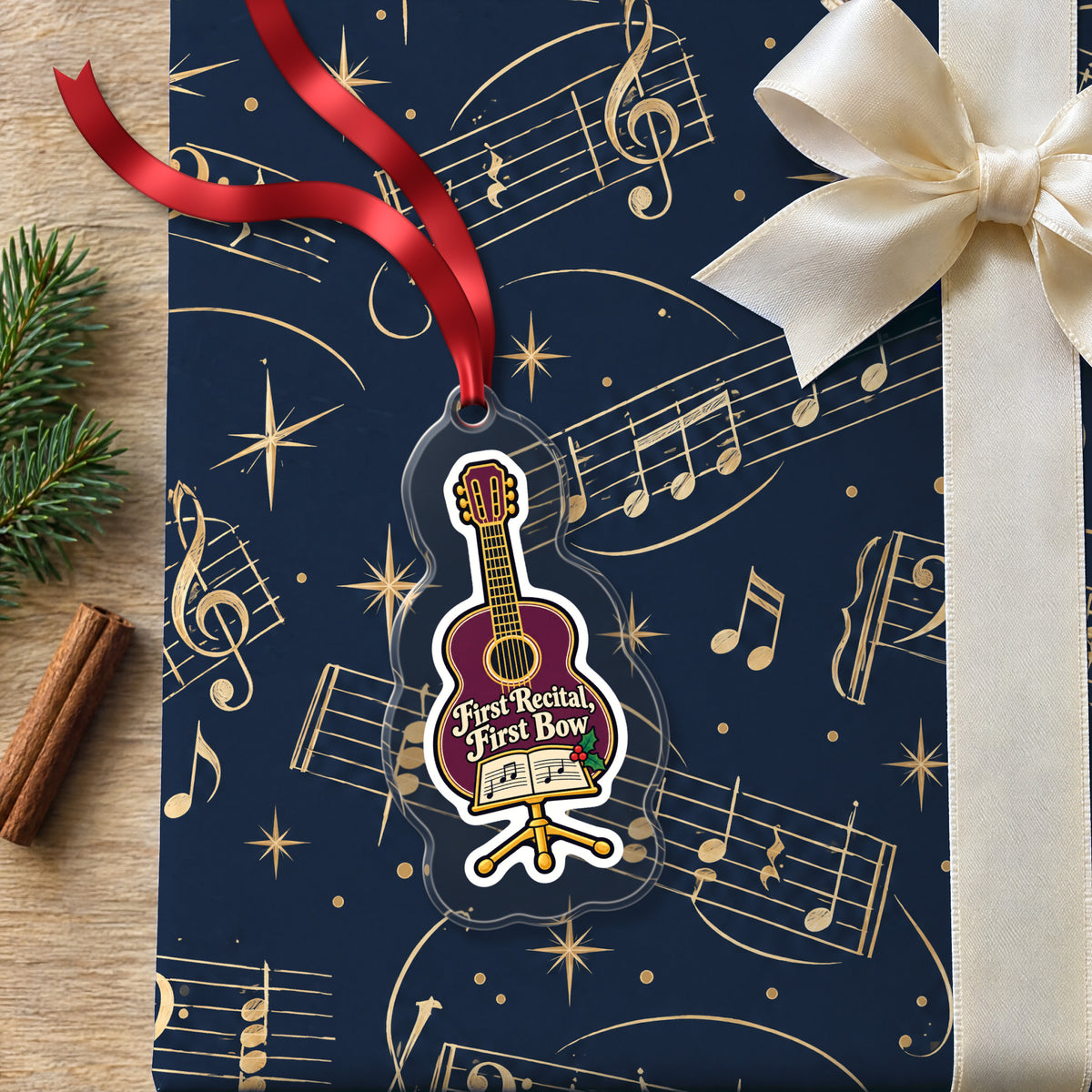 First Recital Acoustic Guitar clear acrylic Christmas ornament lying on a gift wrapped in Rhythm and Beat music wrapping paper