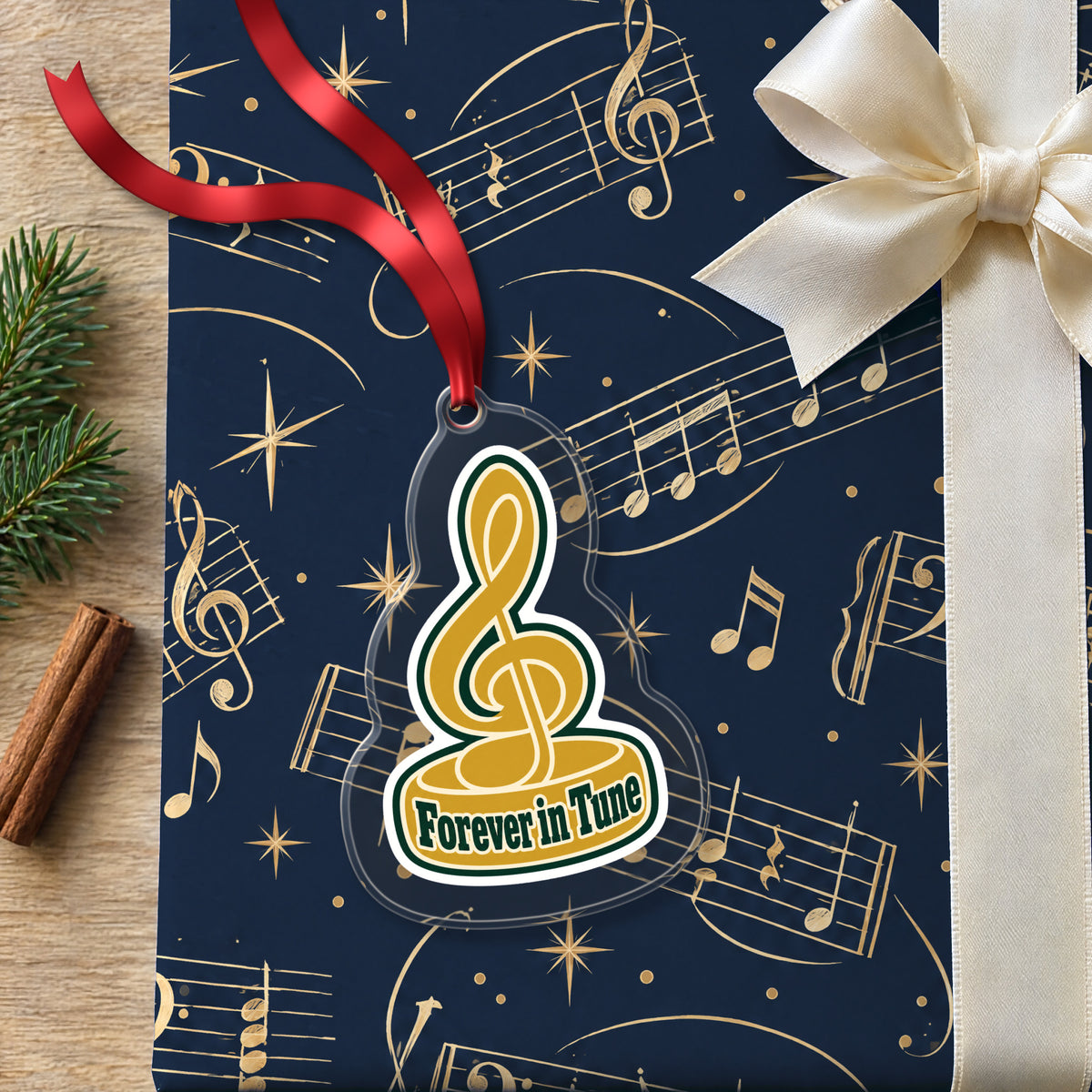 Forever in Tune Treble Clef clear acrylic Christmas ornament lying on a gift wrapped in Rhythm and Beat music wrapping paper