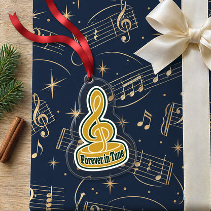 Forever in Tune Treble Clef clear acrylic Christmas ornament lying on a gift wrapped in Rhythm and Beat music wrapping paper