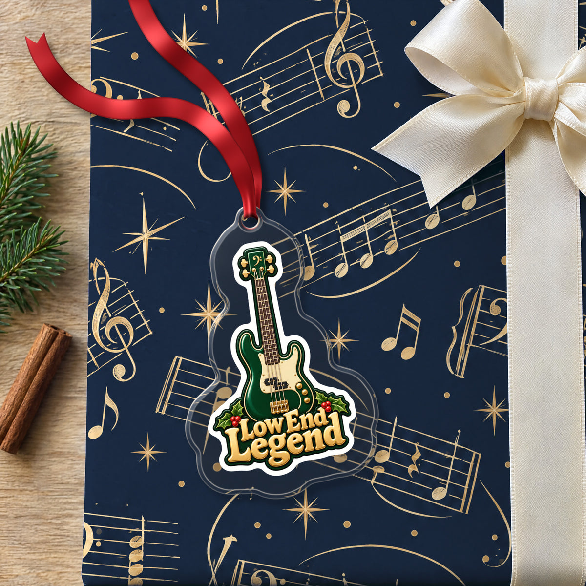 Low End Legend Bass Guitar clear acrylic Christmas ornament lying on a gift wrapped in Rhythm and Beat music wrapping paper