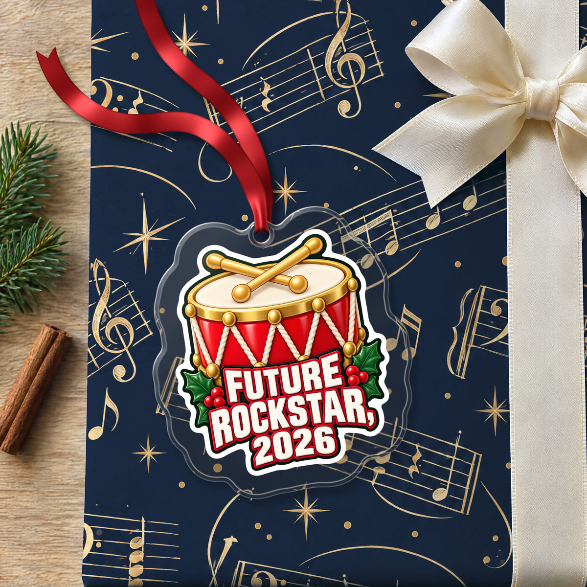 Future Rockstar 2026 Toy Drum clear acrylic Christmas ornament lying on a gift wrapped in Rhythm and Beat music wrapping paper