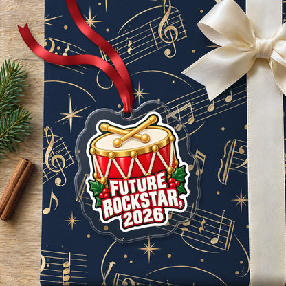 Future Rockstar 2026 Toy Drum clear acrylic Christmas ornament lying on a gift wrapped in Rhythm and Beat music wrapping paper