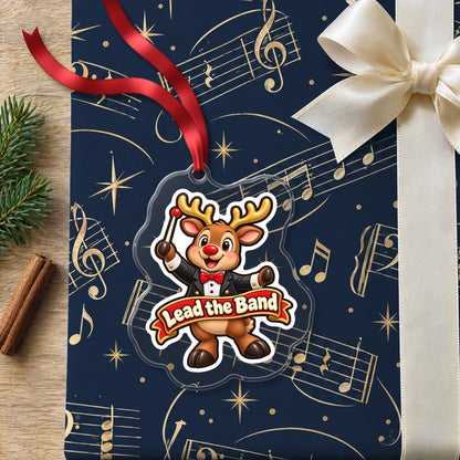 Lead the Band Reindeer Conductor clear acrylic Christmas ornament lying on a gift wrapped in Rhythm and Beat music wrapping paper