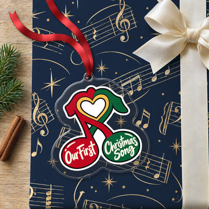 Our First Christmas Song Music Notes clear acrylic Christmas ornament lying on a gift wrapped in Rhythm and Beat music wrapping paper